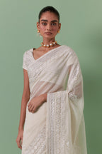 Off-white cotton chanderi saree with delicate silk thread embroidery, highlighted with braids, mirrors and sequins, paired with off white cotton chanderi embroidered blouse with deep round neck and princess seams.