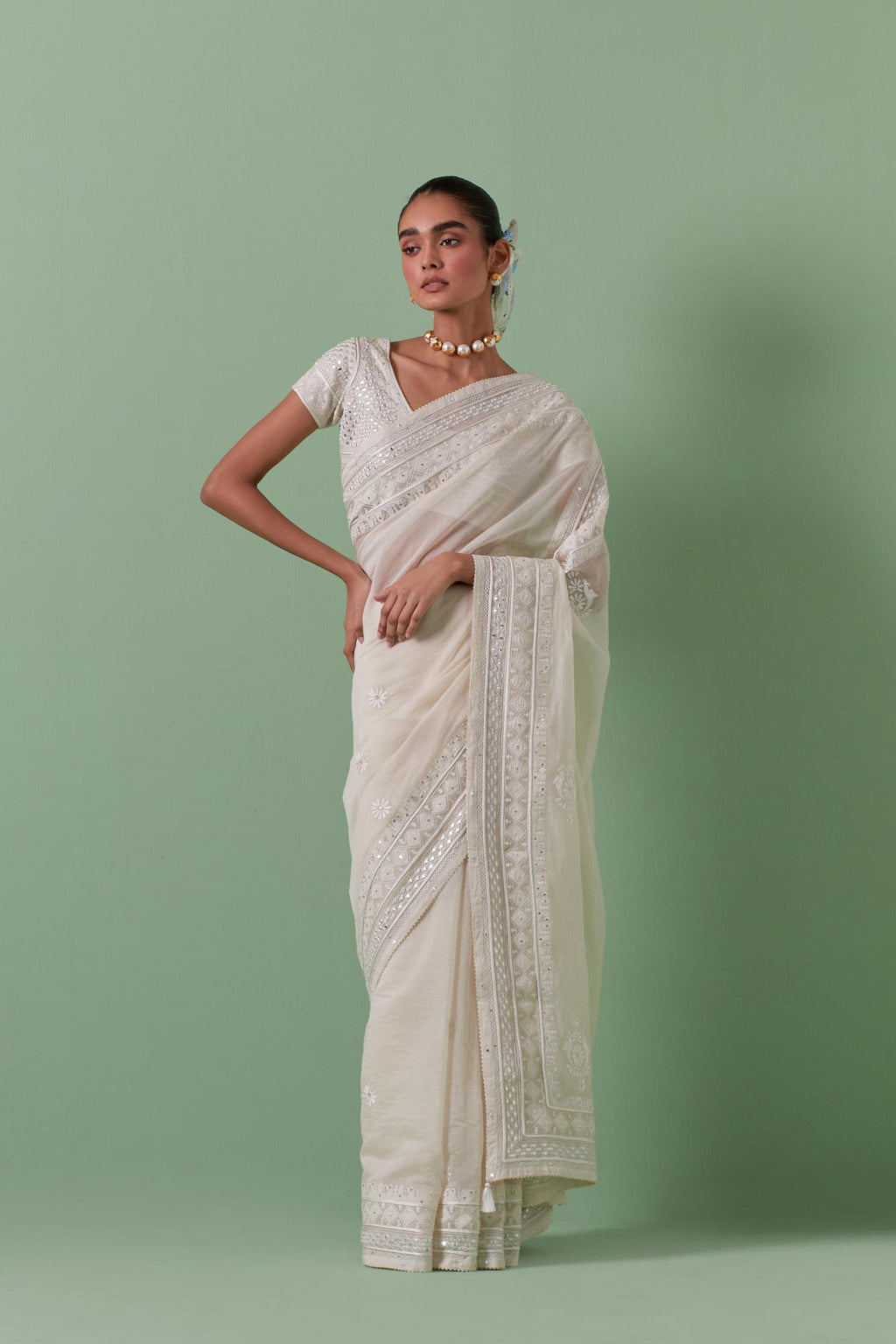 Off-white cotton chanderi saree with delicate silk thread embroidery, highlighted with braids, mirrors and sequins, paired with off white cotton chanderi embroidered blouse with deep round neck and princess seams.