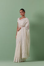 Off-white cotton chanderi saree with delicate silk thread embroidery, highlighted with braids, mirrors and sequins, paired with off white cotton chanderi embroidered blouse with deep round neck and princess seams.