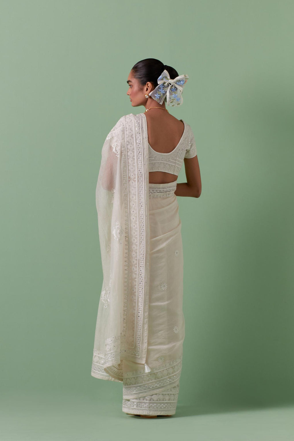 Off-white cotton chanderi saree with delicate silk thread embroidery, highlighted with braids, mirrors and sequins, paired with off white cotton chanderi embroidered blouse with deep round neck and princess seams.