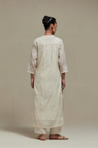 Off white cotton Chanderi straight kurta set with randomly placed appliquéd flowers, highlighted with sequins and beads.
