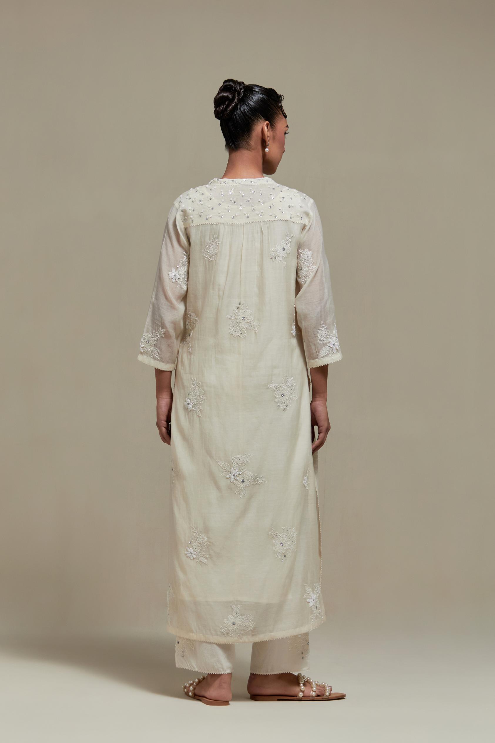 Off white cotton Chanderi straight kurta set with randomly placed appliquéd flowers, highlighted with sequins and beads.