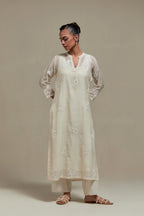 Off white cotton Chanderi straight kurta set with randomly placed appliquéd flowers, highlighted with sequins and beads.