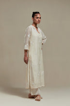 Off white cotton Chanderi straight kurta set with randomly placed appliquéd flowers, highlighted with sequins and beads.