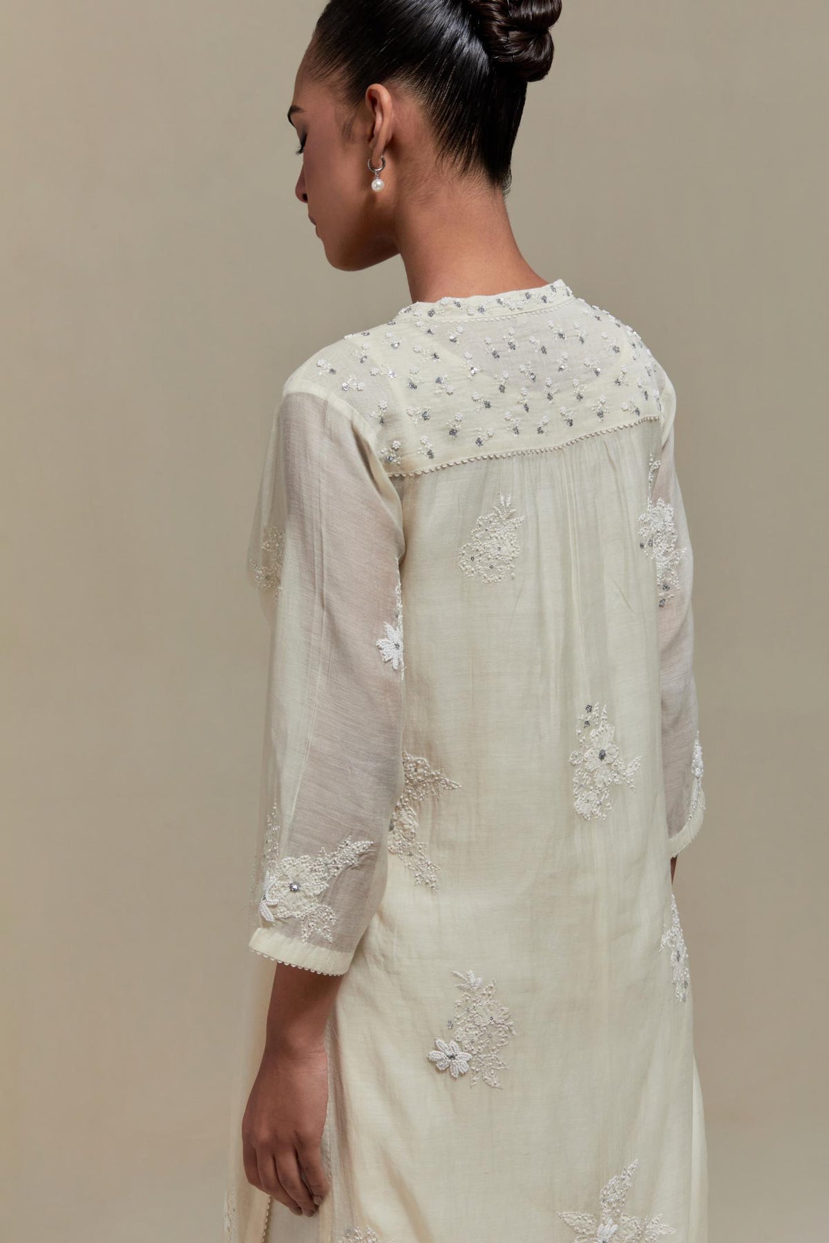 Off white cotton Chanderi straight kurta set with randomly placed appliquéd flowers, highlighted with sequins and beads.