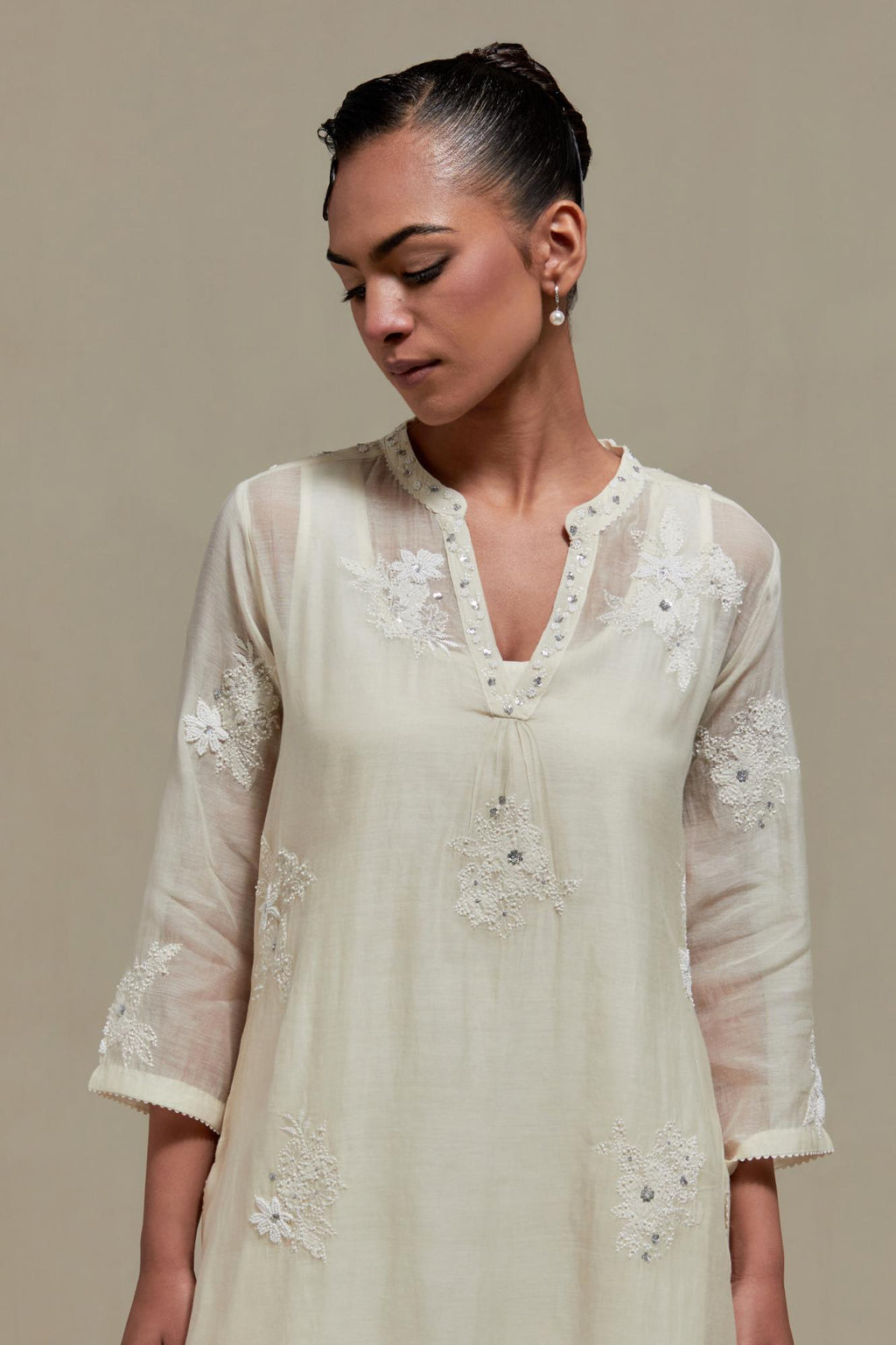 Off white cotton Chanderi straight kurta set with randomly placed appliquéd flowers, highlighted with sequins and beads.