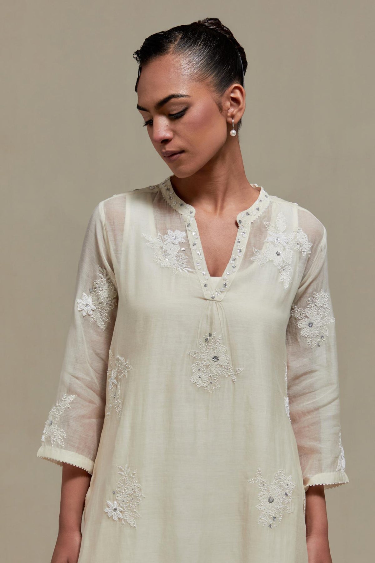 Off white cotton Chanderi straight kurta set with randomly placed appliquéd flowers, highlighted with sequins and beads.