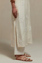 Off white cotton Chanderi straight kurta set with randomly placed appliquéd flowers, highlighted with sequins and beads.