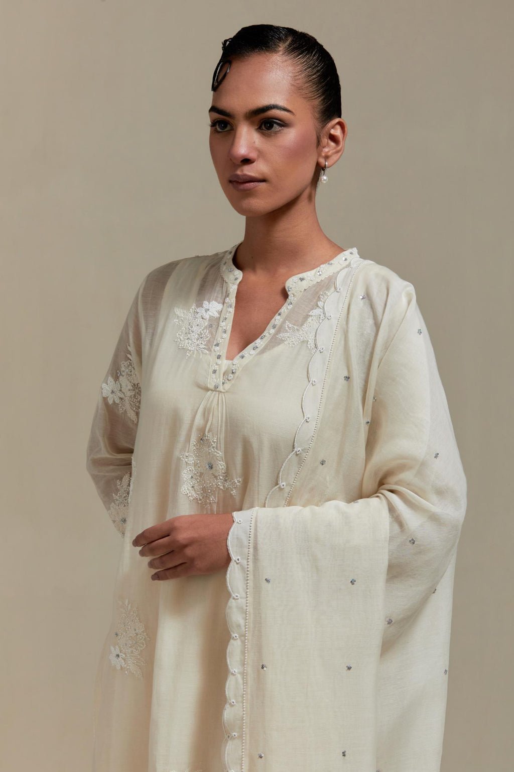 Off white cotton Chanderi dupatta, highlighted with all-over delicate sequins flower and appliqué motifs at dupatta corners.