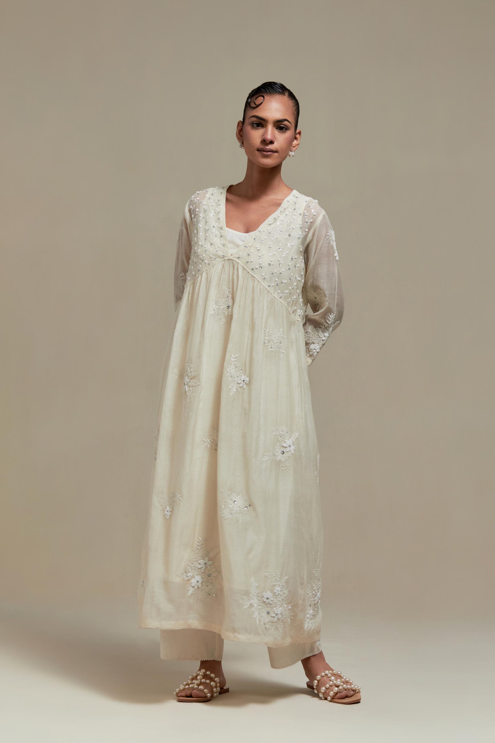 Off white cotton Chanderi kurta dress with delicate embroidered flowers and appliqué motifs, highlighted with sequins and beads.