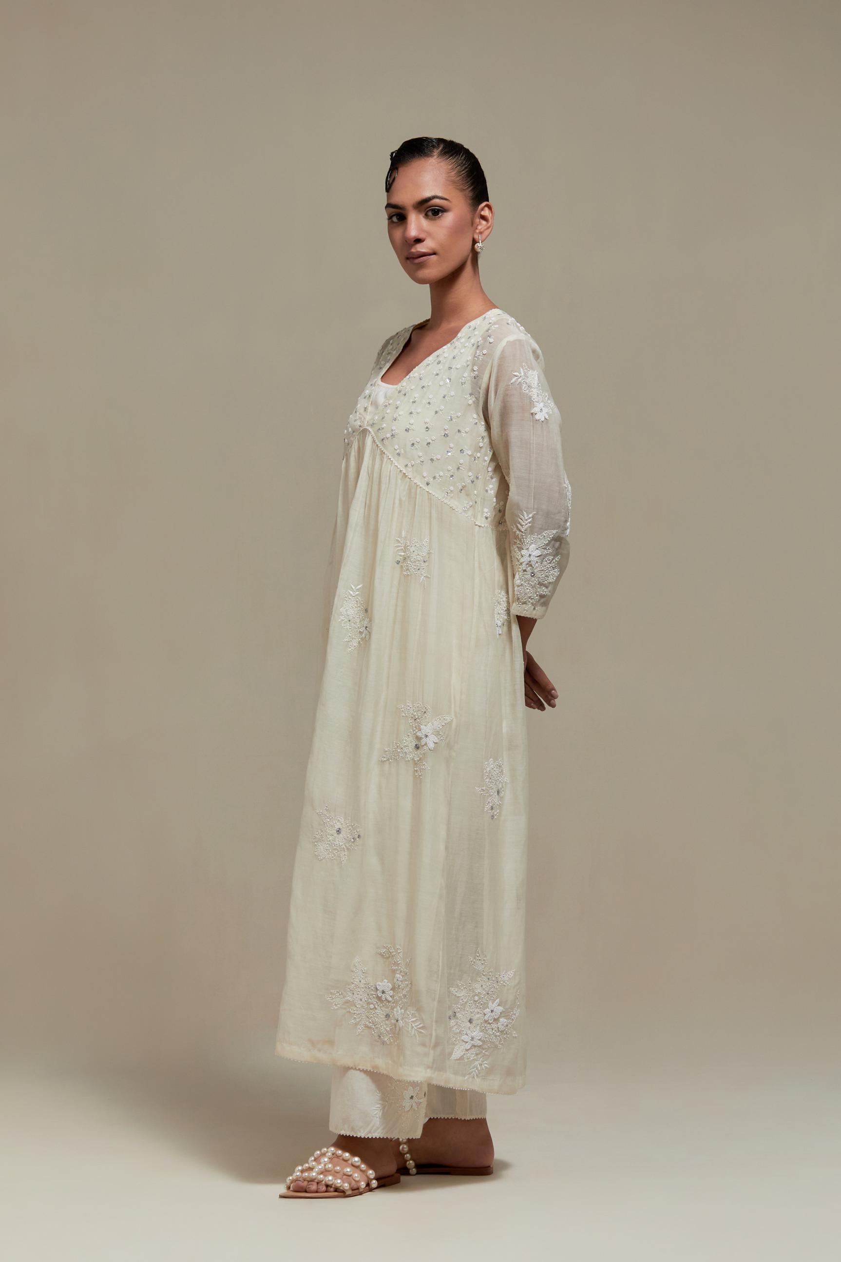 Off white cotton Chanderi kurta dress with delicate embroidered flowers and appliqué motifs, highlighted with sequins and beads.