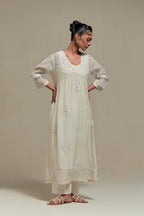 Off white cotton Chanderi kurta dress with delicate embroidered flowers and appliqué motifs, highlighted with sequins and beads.