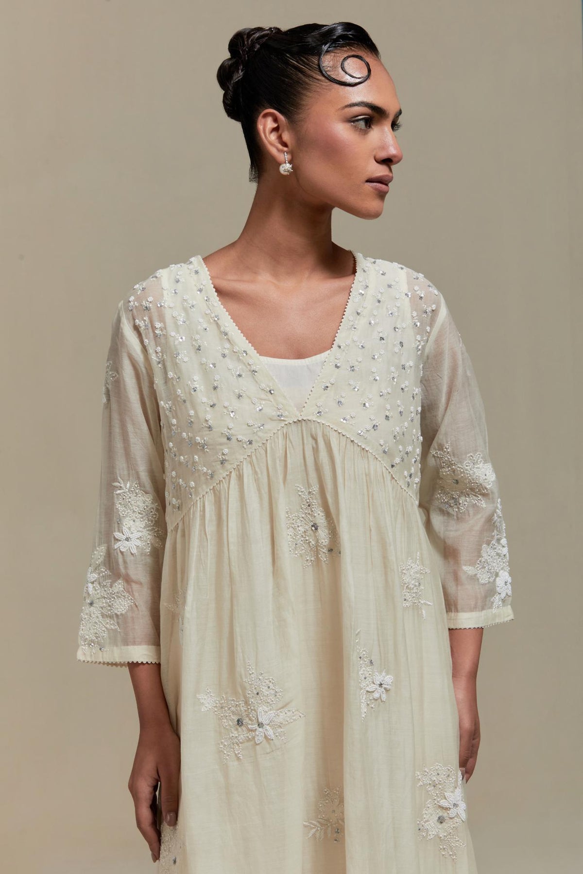 Off white cotton Chanderi kurta dress with delicate embroidered flowers and appliqué motifs, highlighted with sequins and beads.