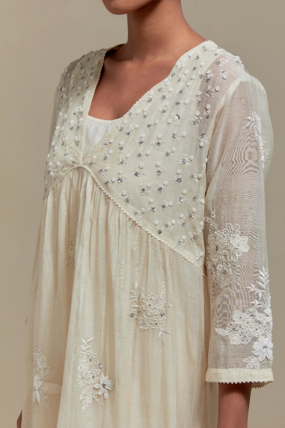Off white cotton Chanderi kurta dress with delicate embroidered flowers and appliqué motifs, highlighted with sequins and beads.