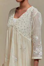 Off white cotton Chanderi kurta dress with delicate embroidered flowers and appliqué motifs, highlighted with sequins and beads.