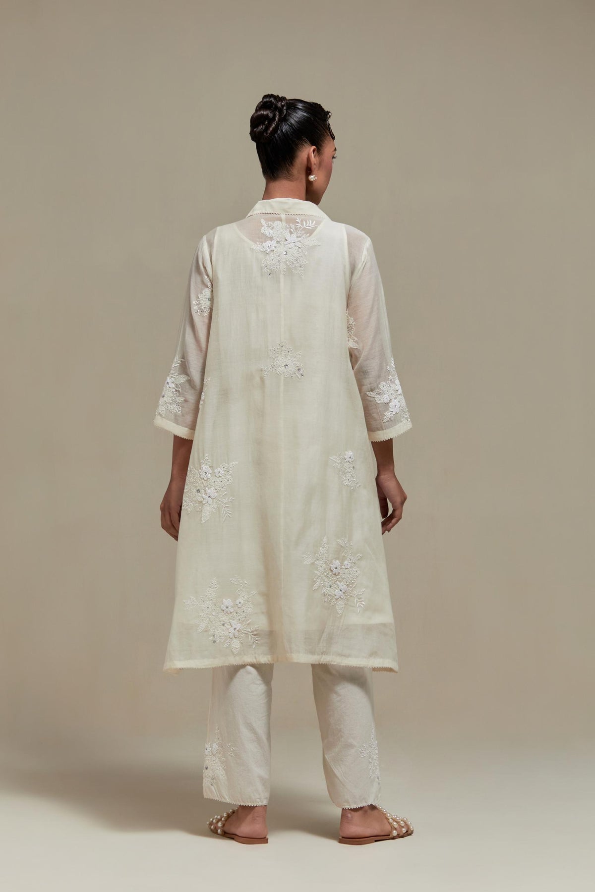 Off white cotton Chanderi short shirt-kurta set with all-over appliqué flowers, highlighted with sequins and beads.