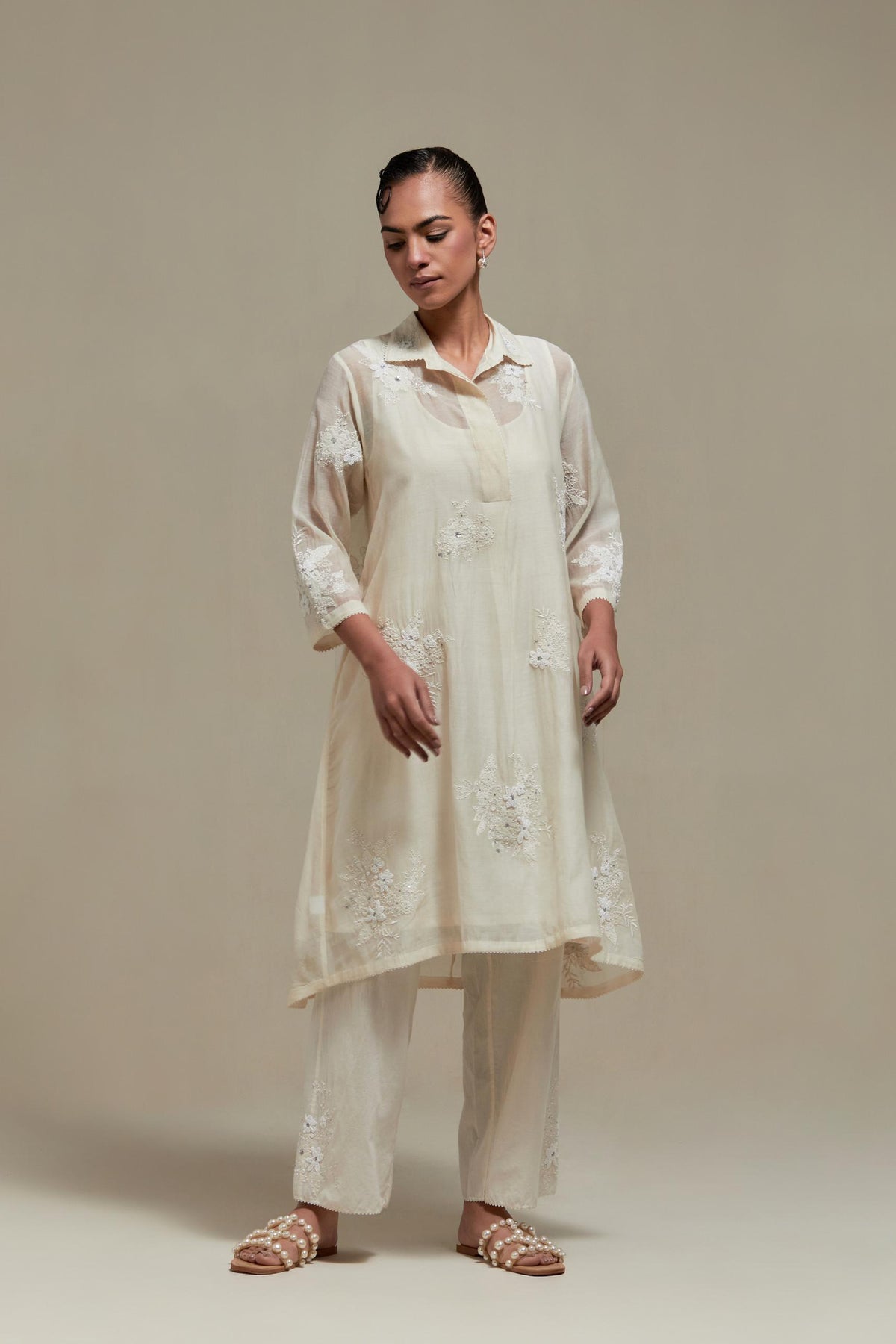Off white cotton Chanderi short shirt-kurta set with all-over appliqué flowers, highlighted with sequins and beads.