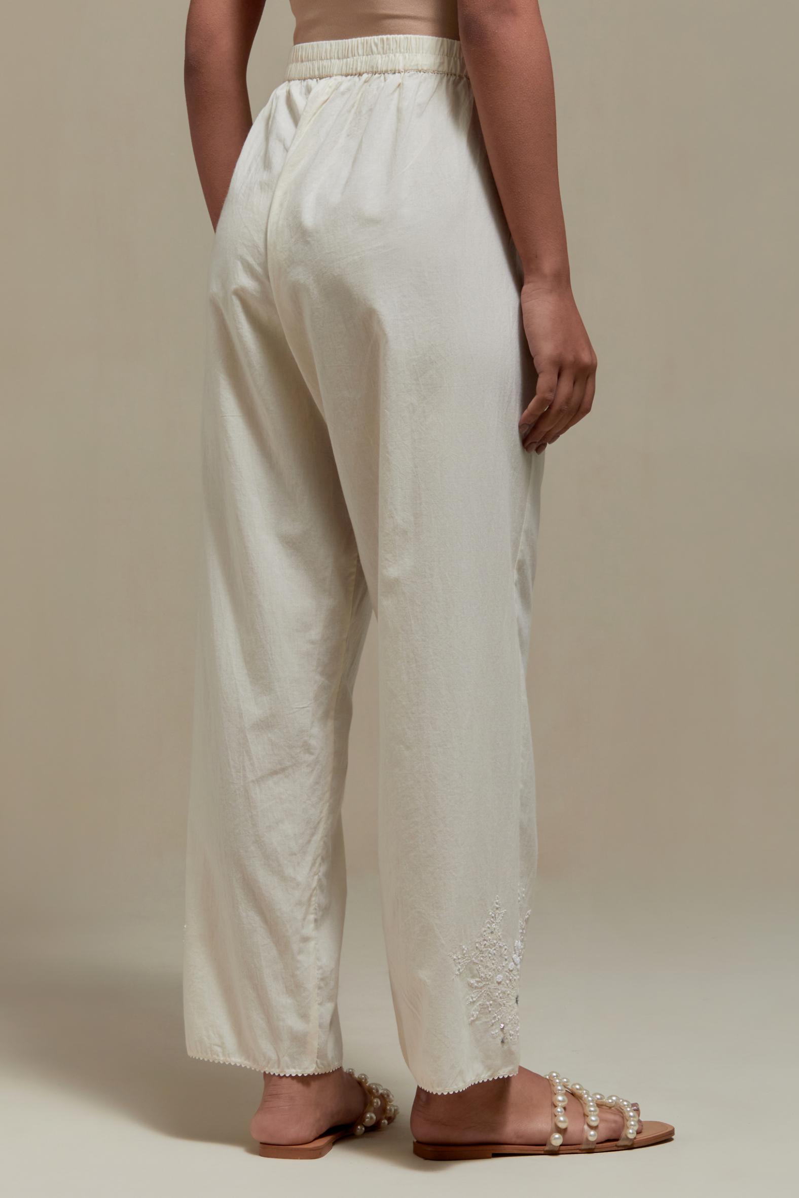 Off white straight pants with appliqué motifs at the sides, highlighted with sequins and beads.