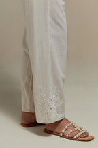 Off white straight pants with appliqué motifs at the sides, highlighted with sequins and beads.
