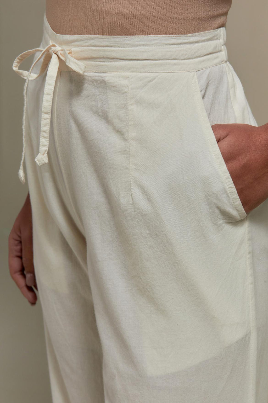 Off white straight pants with appliqué motifs at the sides, highlighted with sequins and beads.