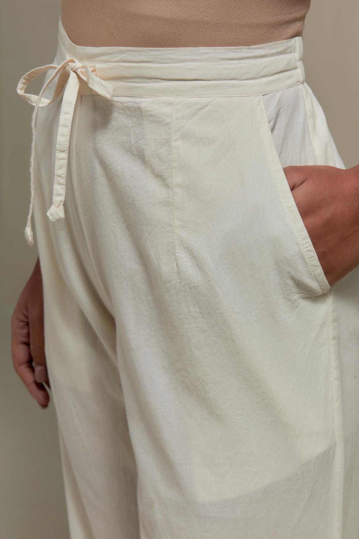 Off white straight pants with appliqué motifs at the sides, highlighted with sequins and beads.