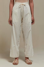 Off white straight pants with appliqué motifs at the sides, highlighted with sequins and beads.