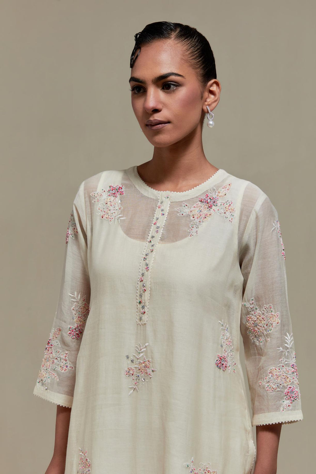 Off white straight kurta set with all-over pink & beige hand block printed appliqué motifs, highlighted with sequins and multi coloured beads.
