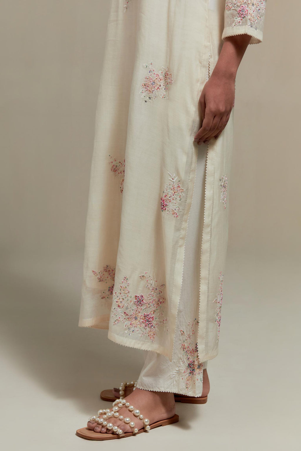 Off white straight kurta set with all-over pink & beige hand block printed appliqué motifs, highlighted with sequins and multi coloured beads.