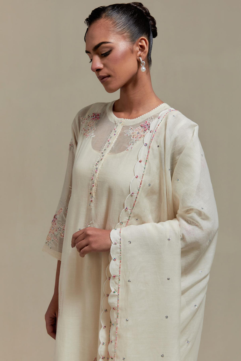 Off white cotton Chanderi dupatta, highlighted with all-over delicate sequins flower and pink & beige hand block printed appliqué motifs at dupatta corners.