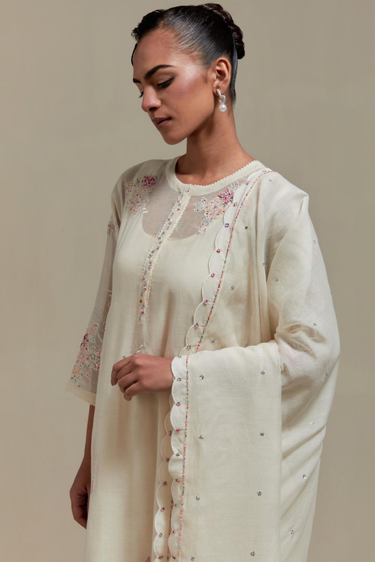 Off white straight kurta set with all-over pink & beige hand block printed appliqué motifs, highlighted with sequins and multi coloured beads.