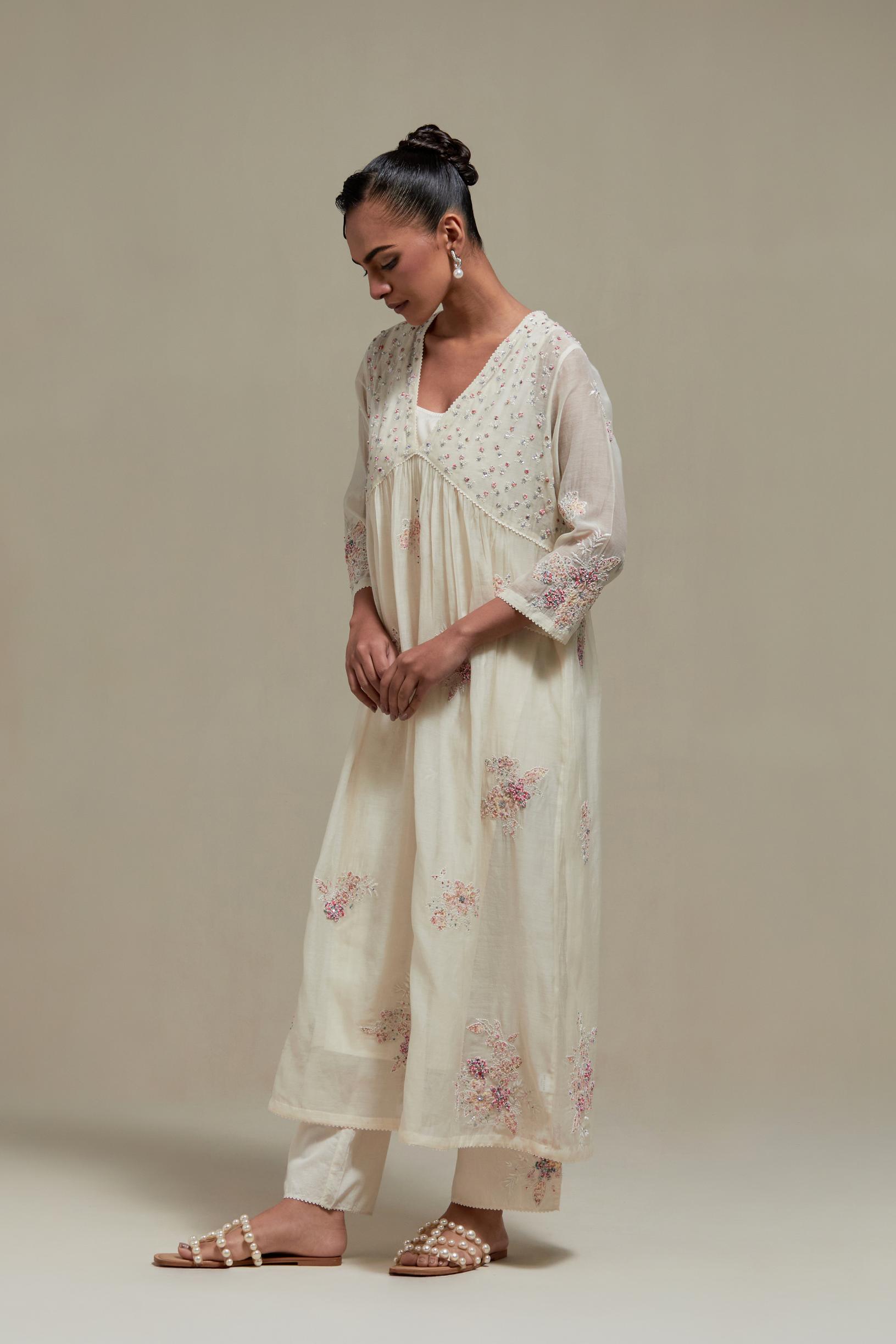 Off white cotton Chanderi kurta dress set with delicate embroidered flowers and pink & beige hand block printed appliqué motifs, highlighted with sequins and multi coloured beads.