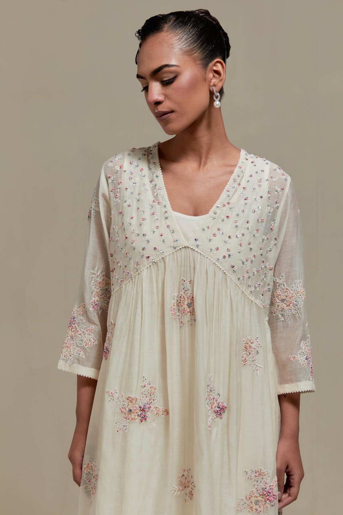 Off white cotton Chanderi kurta dress set with delicate embroidered flowers and pink & beige hand block printed appliqué motifs, highlighted with sequins and multi coloured beads.