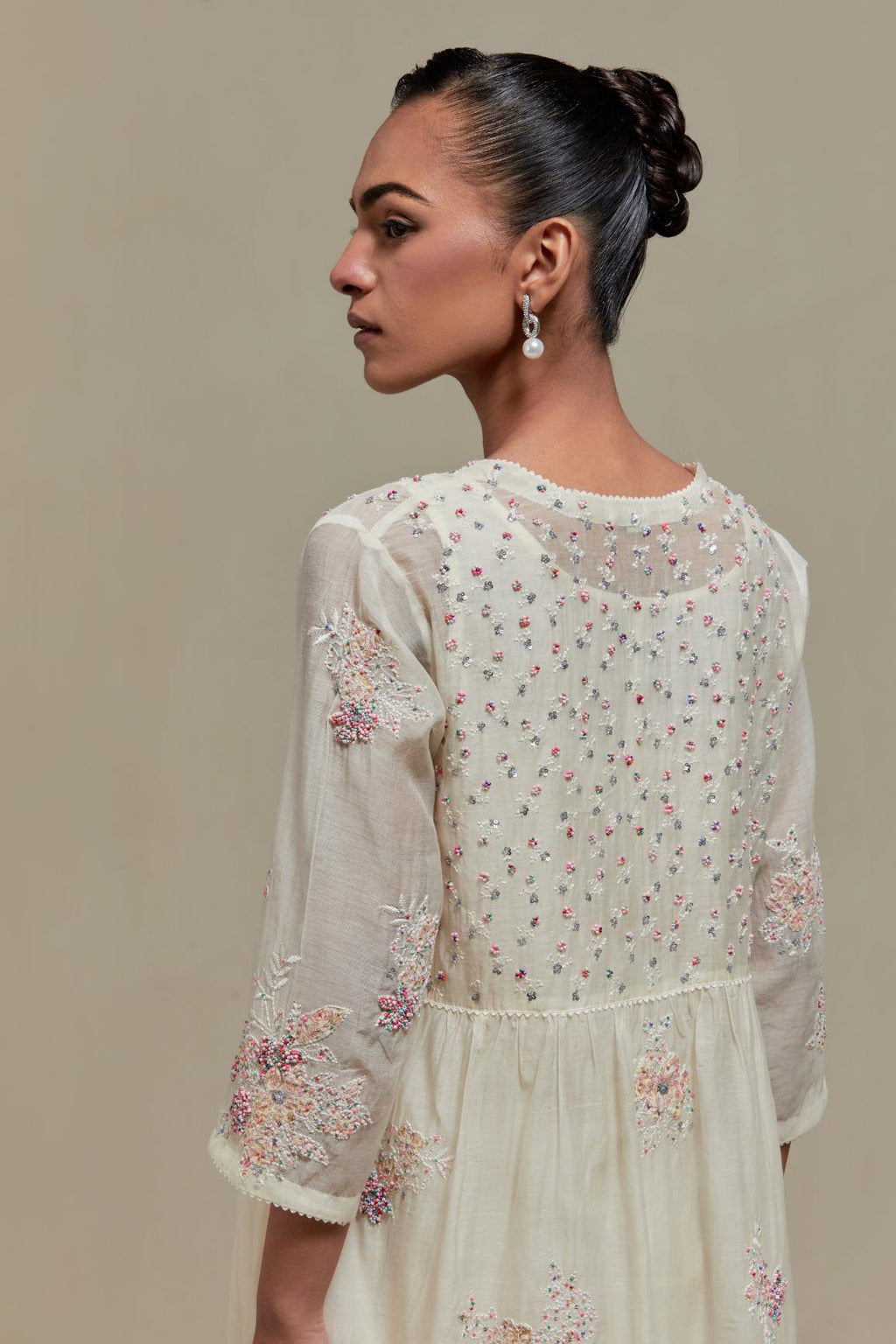 Off white cotton Chanderi kurta dress set with delicate embroidered flowers and pink & beige hand block printed appliqué motifs, highlighted with sequins and multi coloured beads.