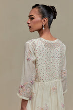 Off white cotton Chanderi kurta dress set with delicate embroidered flowers and pink & beige hand block printed appliqué motifs, highlighted with sequins and multi coloured beads.