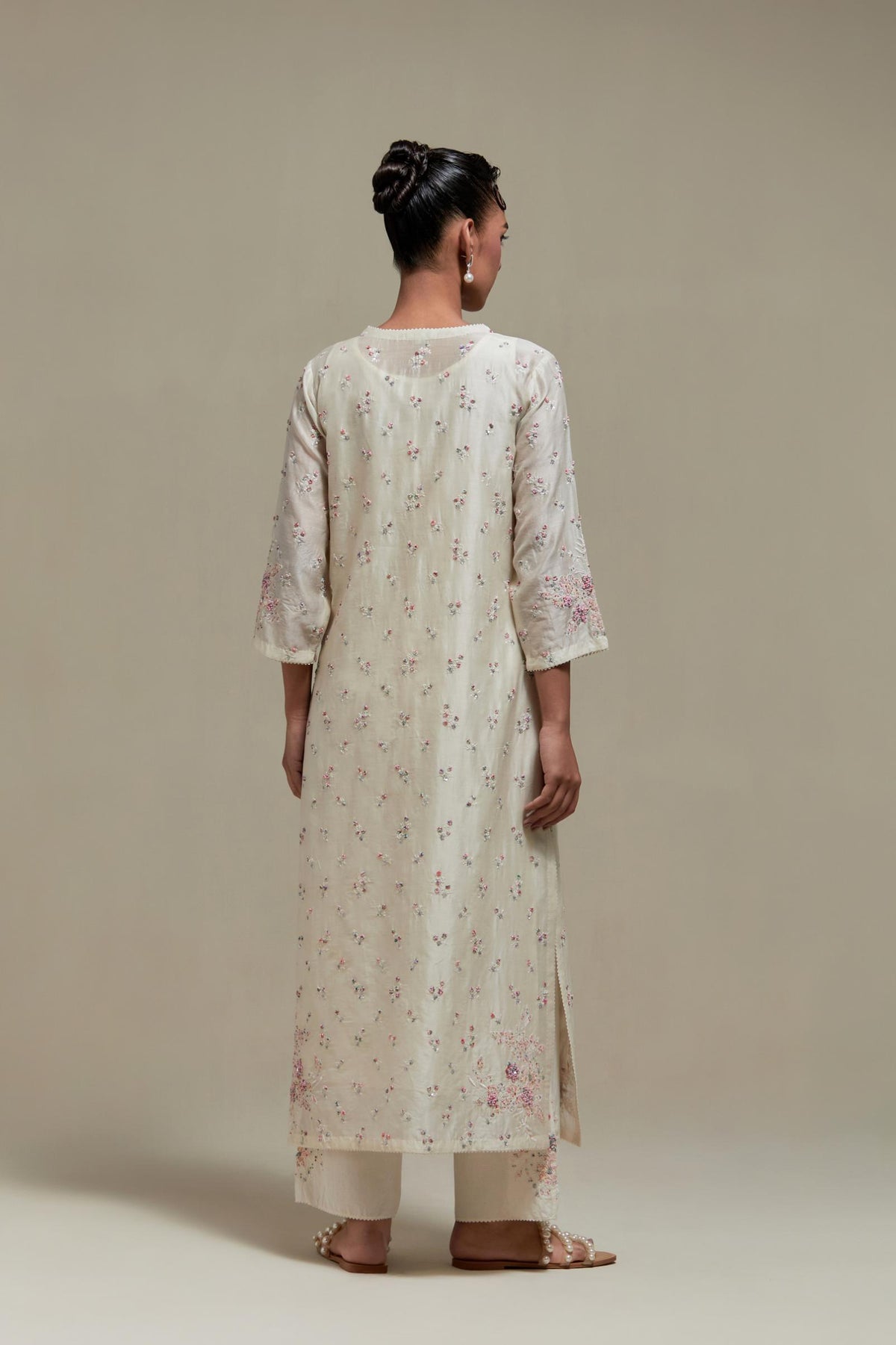 Off white silk Chanderi straight kurta set with all-over delicate embroidered flowers, highlighted with sequins and multi coloured beads.