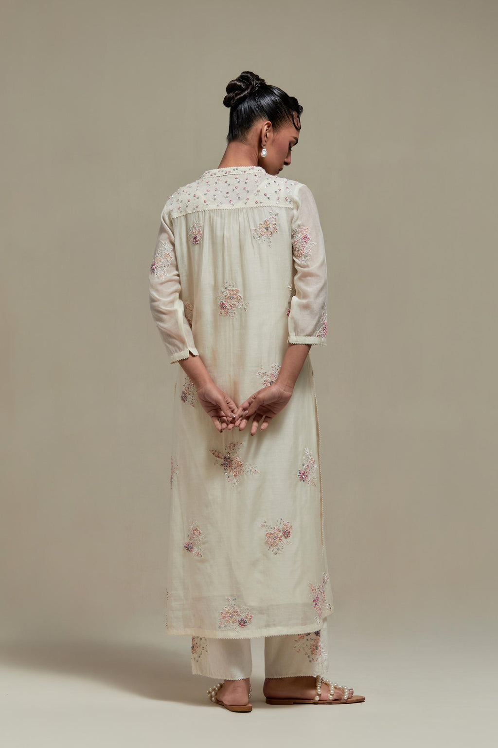 Off white cotton Chanderi straight kurta set with randomly placed pink & beige hand block printed appliquéd flowers, highlighted with sequins and multi coloured beads.