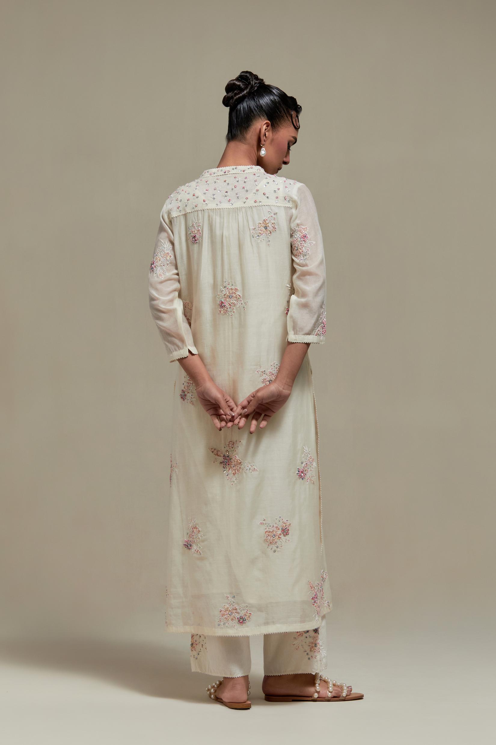 Off white cotton Chanderi straight kurta set with randomly placed pink & beige hand block printed appliquéd flowers, highlighted with sequins and multi coloured beads.