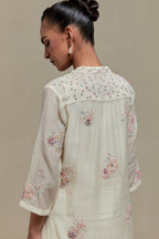 Off white cotton Chanderi straight kurta set with randomly placed pink & beige hand block printed appliquéd flowers, highlighted with sequins and multi coloured beads.