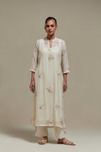 Off white cotton Chanderi straight kurta set with randomly placed pink & beige hand block printed appliquéd flowers, highlighted with sequins and multi coloured beads.
