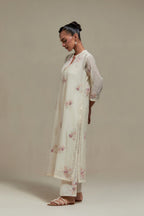 Off white cotton Chanderi straight kurta set with randomly placed pink & beige hand block printed appliquéd flowers, highlighted with sequins and multi coloured beads.