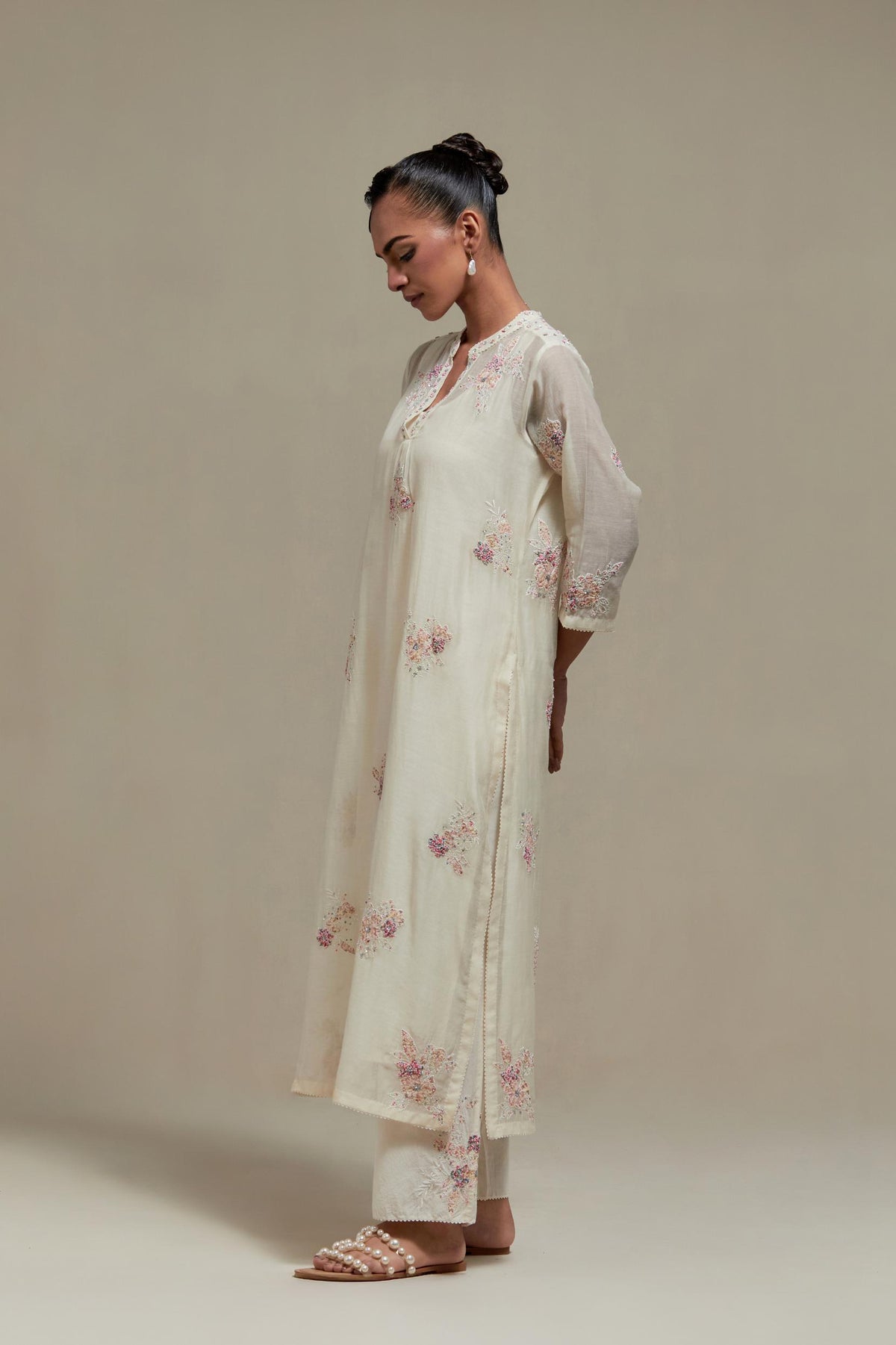 Off white cotton Chanderi straight kurta set with randomly placed pink & beige hand block printed appliquéd flowers, highlighted with sequins and multi coloured beads.