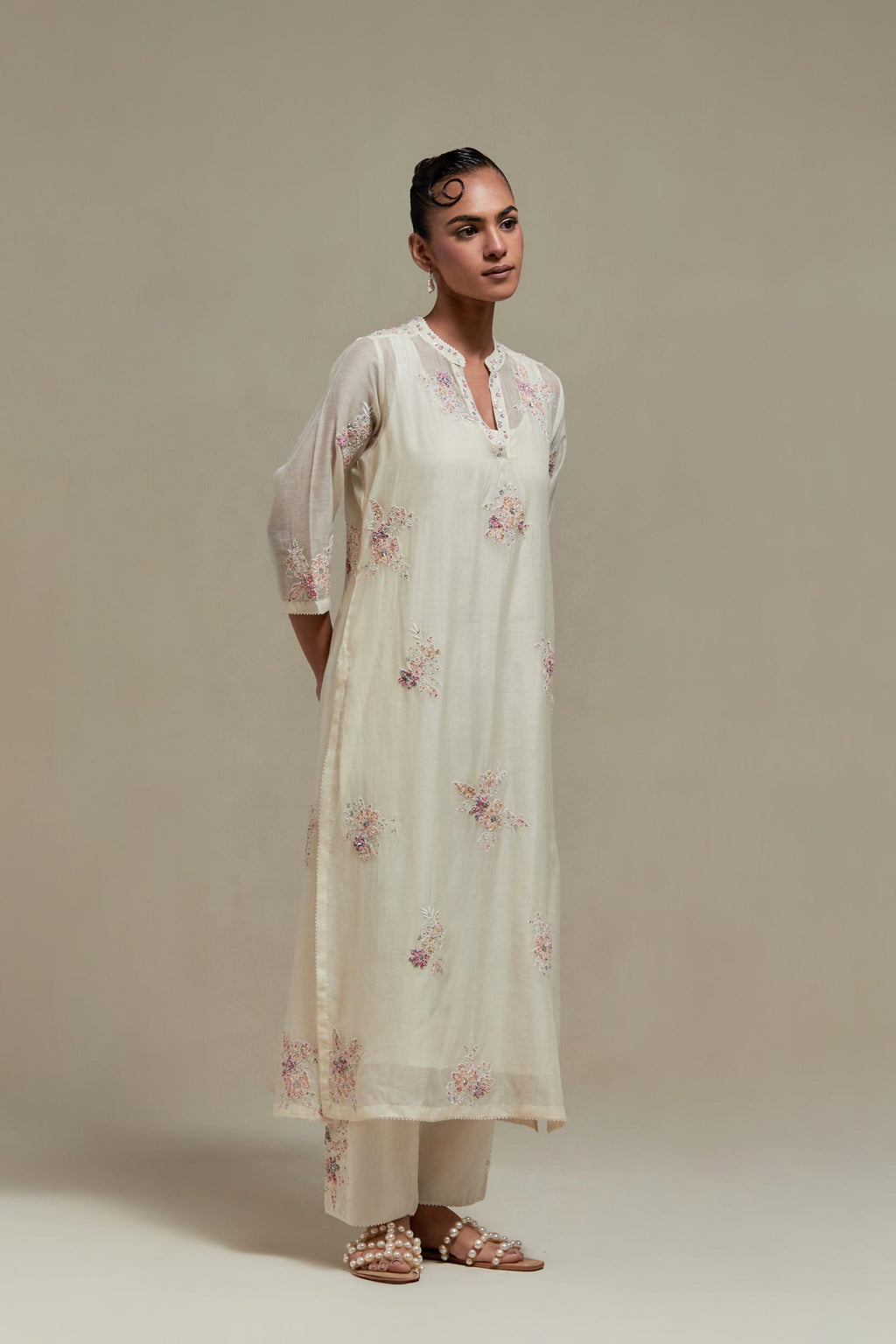 Off white cotton Chanderi straight kurta set with randomly placed pink & beige hand block printed appliquéd flowers, highlighted with sequins and multi coloured beads.