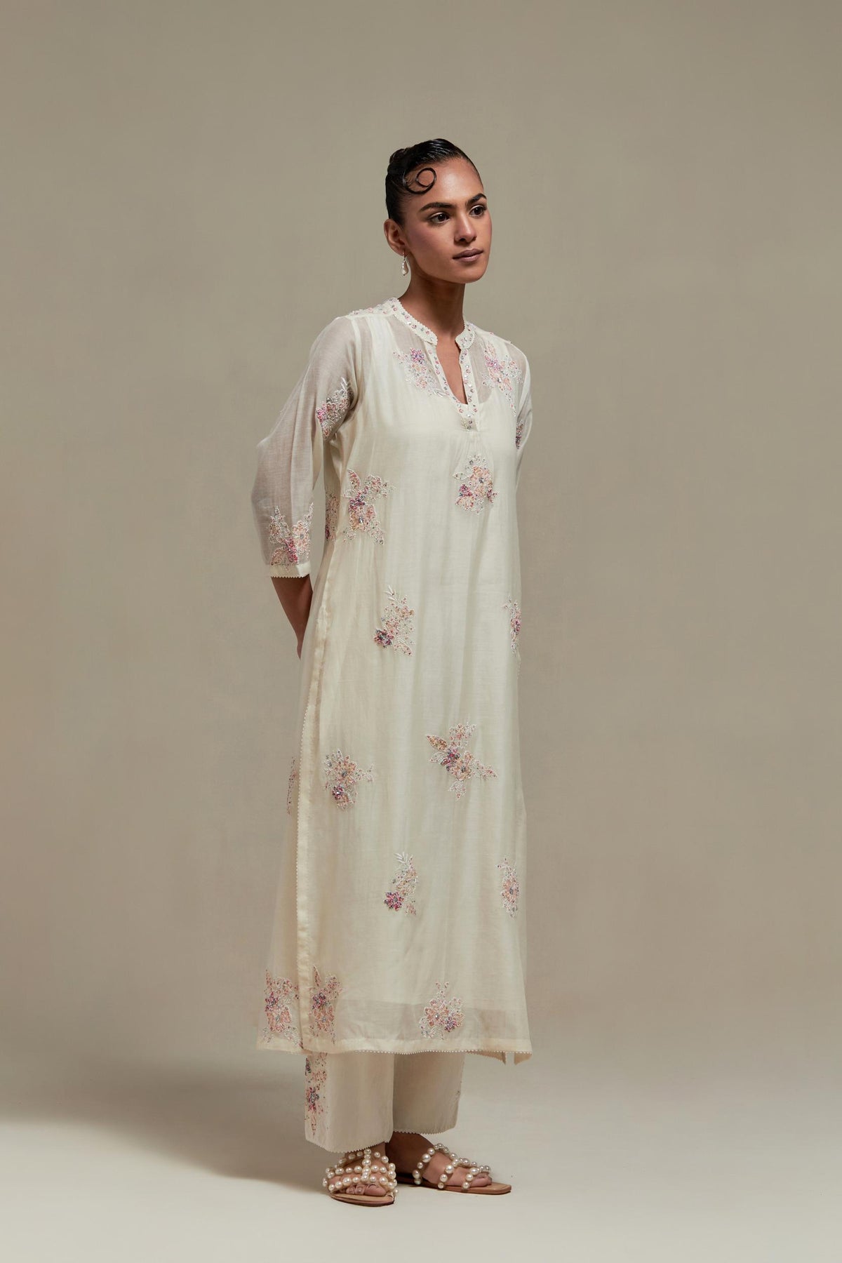 Off white cotton Chanderi straight kurta set with randomly placed pink & beige hand block printed appliquéd flowers, highlighted with sequins and multi coloured beads.