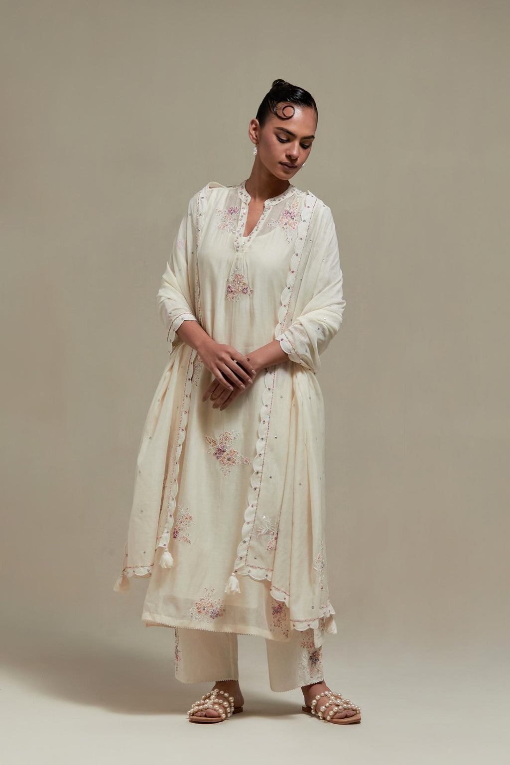 Off white cotton Chanderi straight kurta set with randomly placed pink & beige hand block printed appliquéd flowers, highlighted with sequins and multi coloured beads.