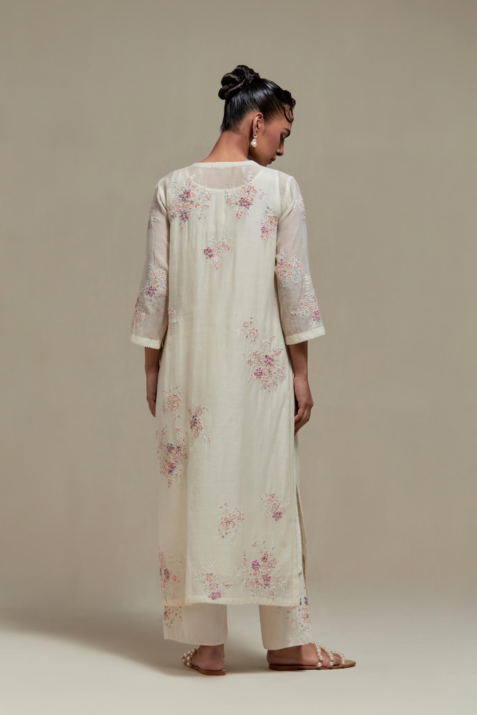 Off white cotton Chanderi straight kurta set with randomly placed pink & beige hand block printed appliquéd flowers, highlighted with sequins and multi coloured beads.