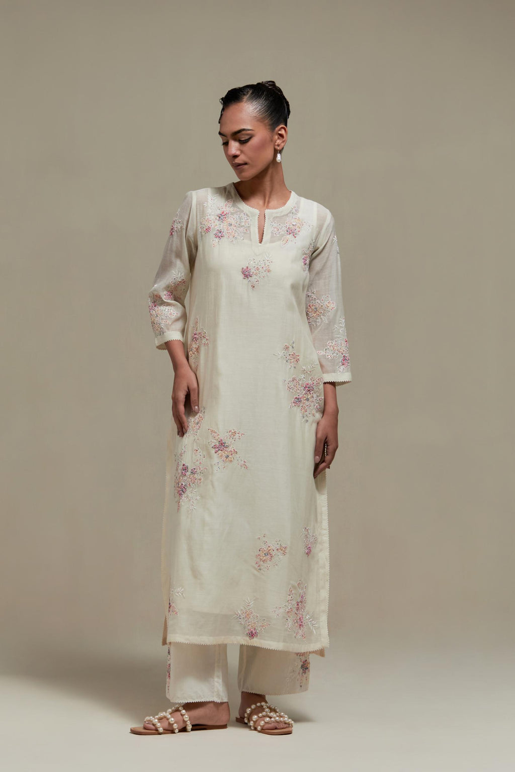 Off white cotton Chanderi straight kurta set with randomly placed pink & beige hand block printed appliquéd flowers, highlighted with sequins and multi coloured beads.