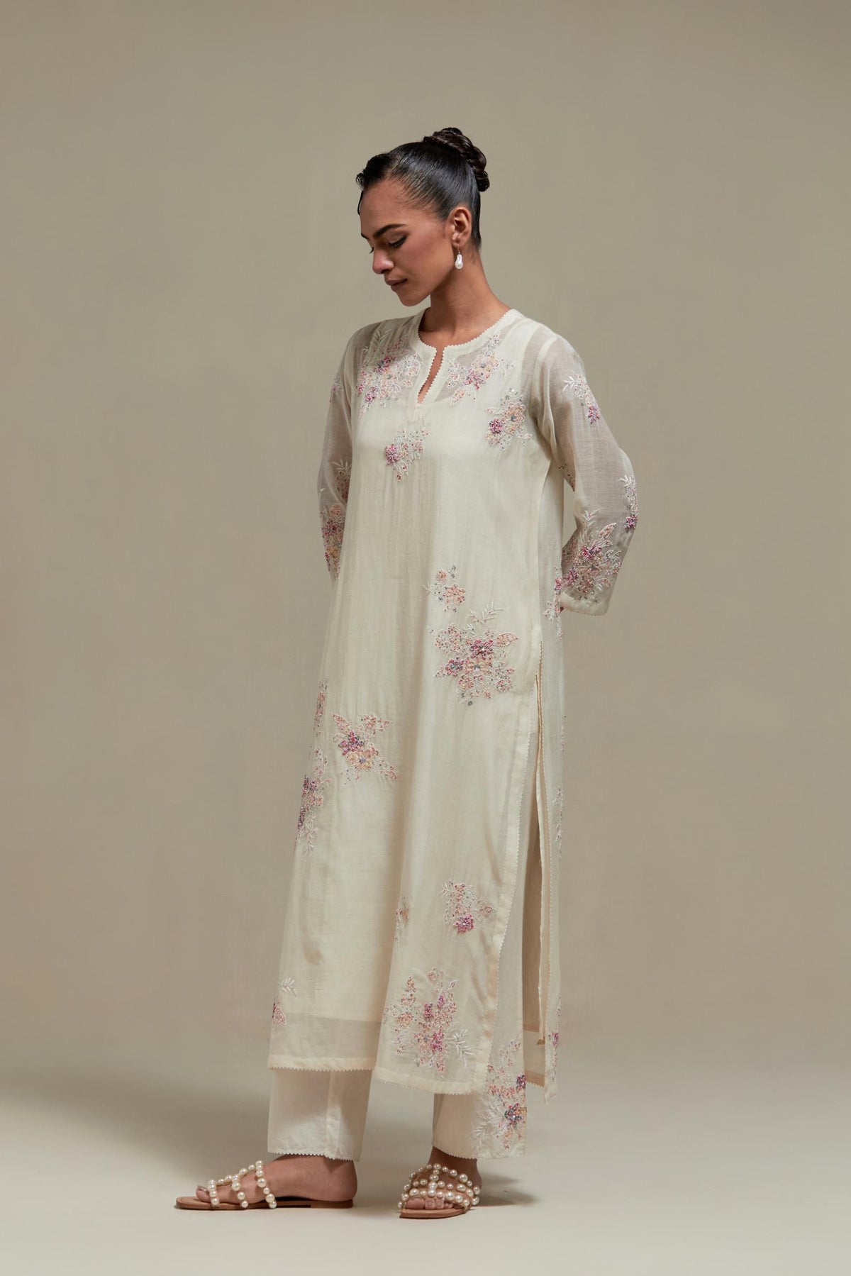 Off white cotton Chanderi straight kurta set with randomly placed pink & beige hand block printed appliquéd flowers, highlighted with sequins and multi coloured beads.