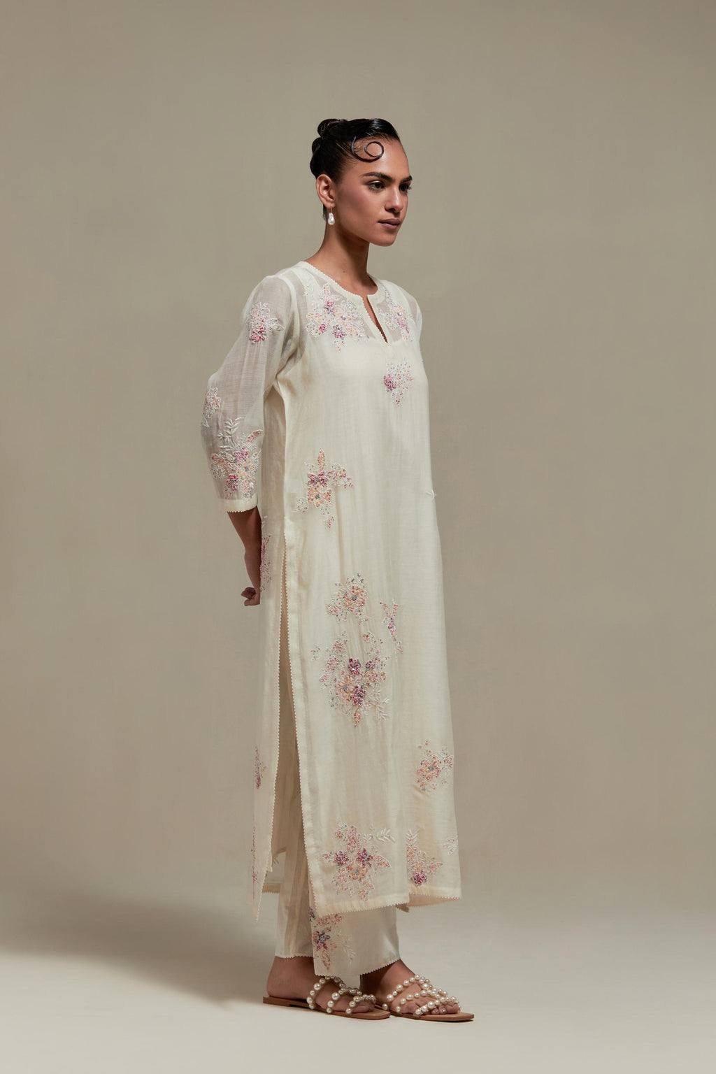 Off white cotton Chanderi straight kurta set with randomly placed pink & beige hand block printed appliquéd flowers, highlighted with sequins and multi coloured beads.