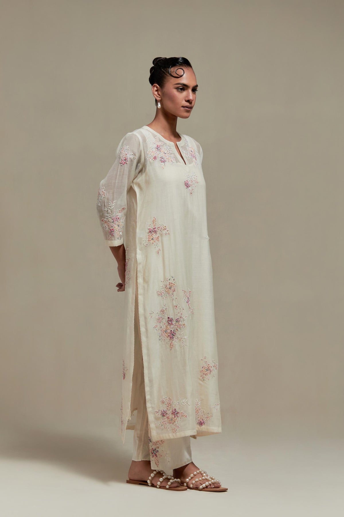 Off white cotton Chanderi straight kurta set with randomly placed pink & beige hand block printed appliquéd flowers, highlighted with sequins and multi coloured beads.
