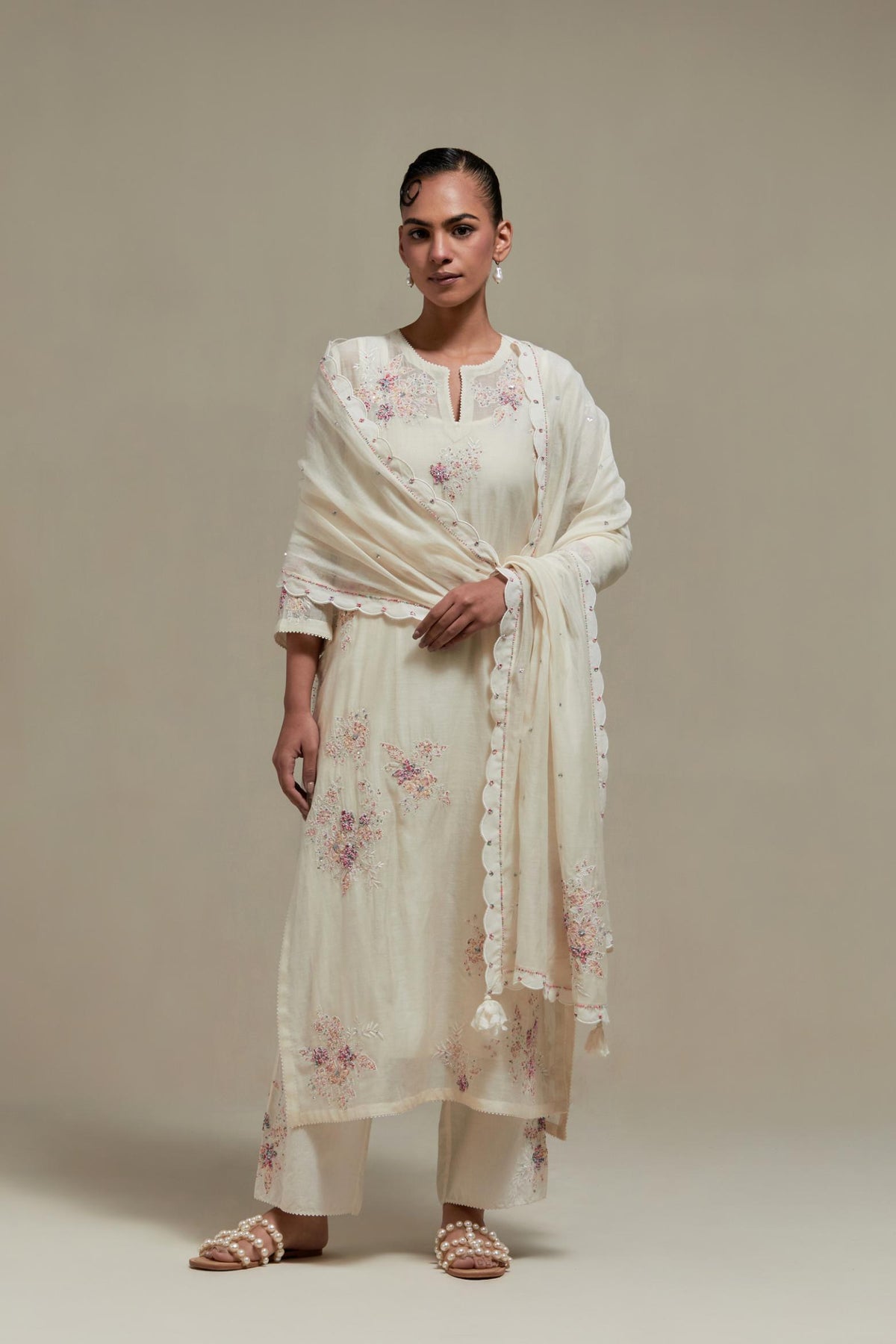 Off white cotton Chanderi straight kurta set with randomly placed pink & beige hand block printed appliquéd flowers, highlighted with sequins and multi coloured beads.